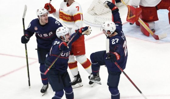 Team USA's Noah Cates, right, celebrates with teammates after scoring a goal against host China in the Winter Olympics at the National Indoor Stadium in Beijing on Thursday.