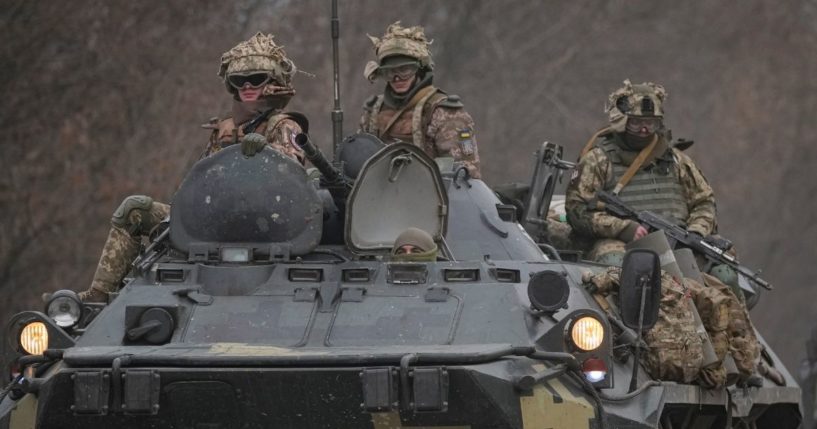 Ukrainian servicemen sit atop armored personnel carriers in the Donetsk region, eastern Ukraine, on Thursday.