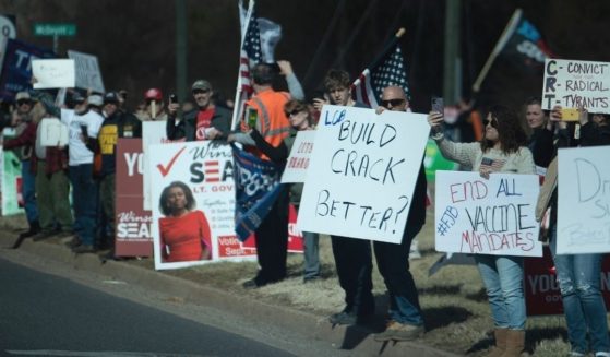 Protesters greet a motorcade with President Joe Biden en route to Germanna Community College in Culpeper, Virginia, on Thursday.
