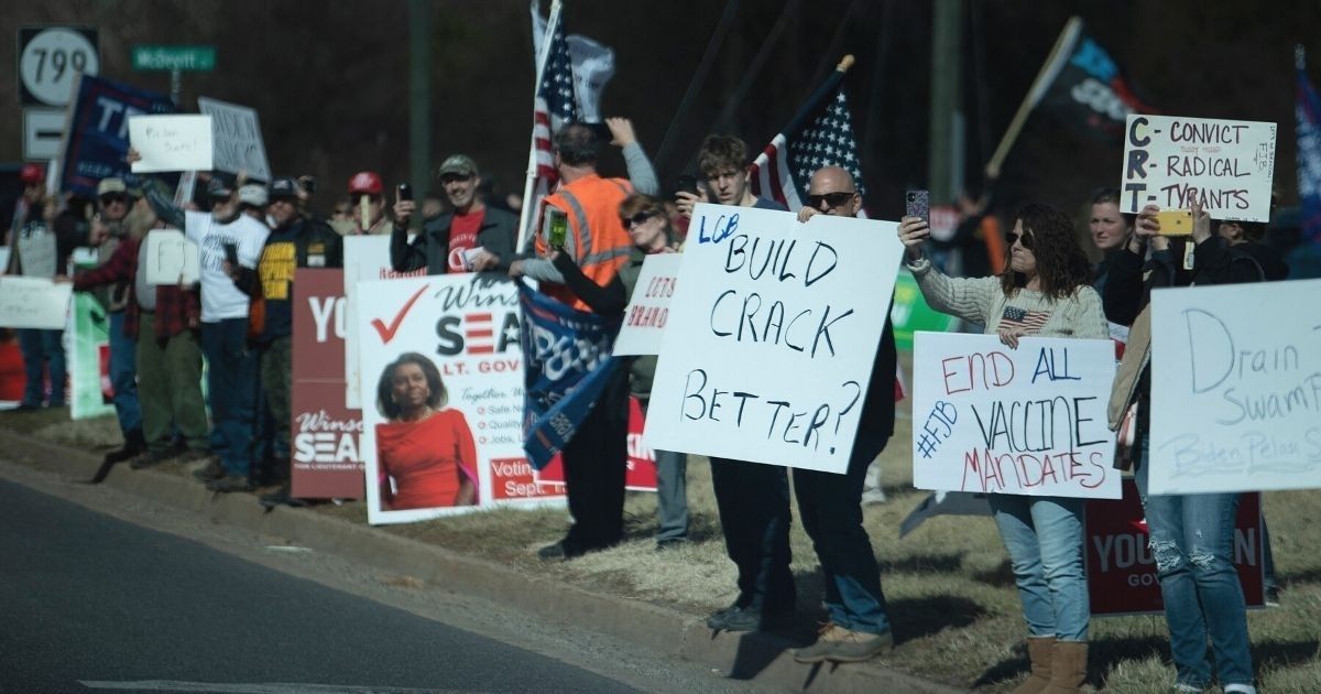Protesters greet a motorcade with President Joe Biden en route to Germanna Community College in Culpeper, Virginia, on Thursday.
