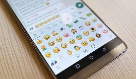Emojis are displayed on a phone screen in the above stock image.