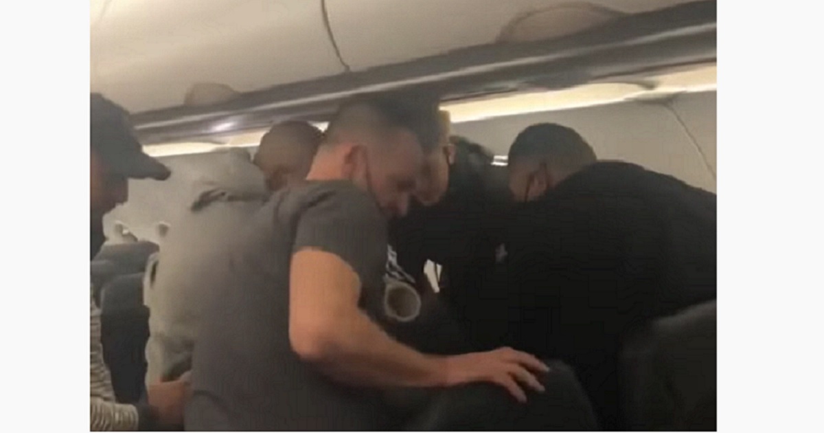 Passenger subdue an unruly man aboard a flight from New York City to Orlando, Florida, on Wednesday.
