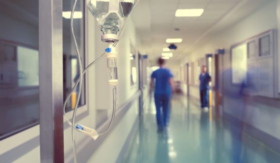 Medical workers walk down a hospital hallway in the above stock image.