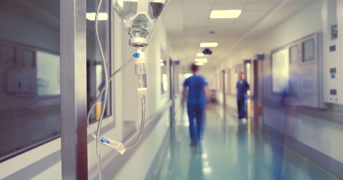 Medical workers walk down a hospital hallway in the above stock image.