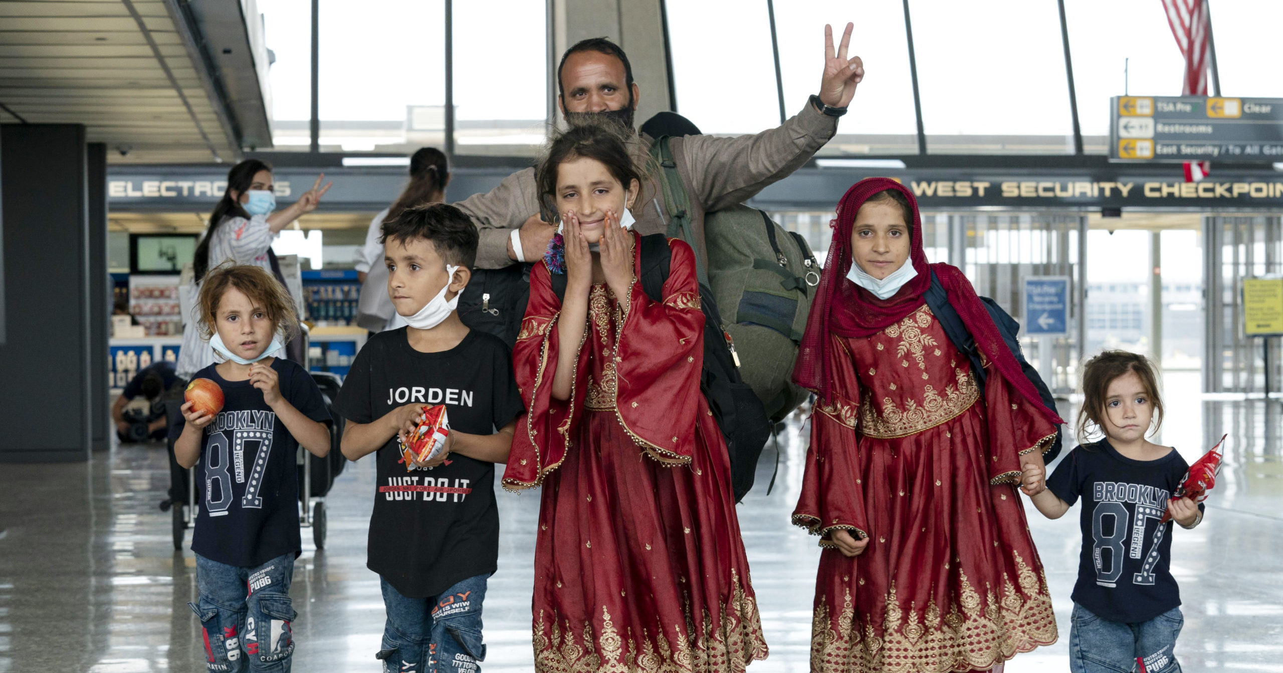 Families evacuated from Kabul, Afghanistan, walk through the terminal after arriving at Washington Dulles International Airport in Chantilly, Virginia, on Aug. 27, 2021.
