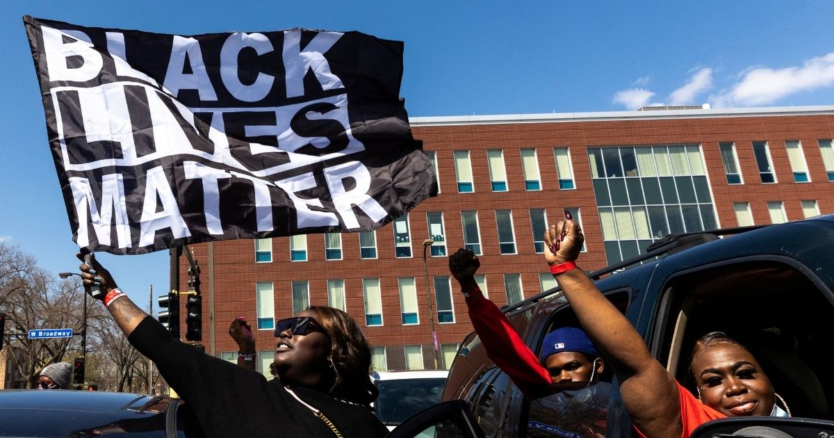 A woman holds a Black Lives Matter flag during the funeral for Daunte Wright outside the Shiloh Temple International Ministries in Minneapolis on April 22, 2021.
