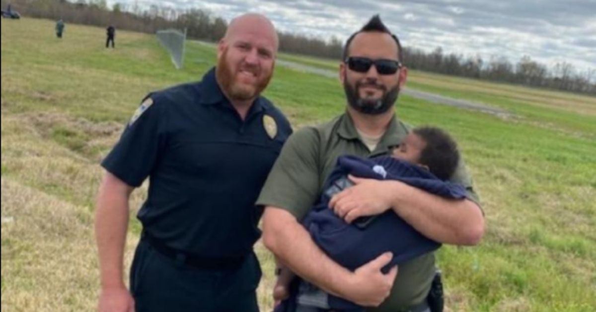 Members of a search team consisting of Baton Rouge police officers, Baton Rouge Fire Department, Parish Search and Rescue, East Baton Rouge Coroner's Office, Emergency Medical Services, Acadian Ambulance and hospital staff hold an 8-month-old infant who had been missing but was found safe.