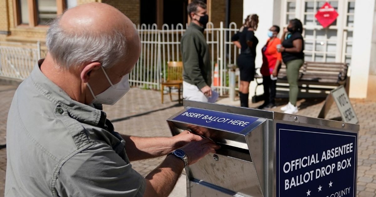 A man places a ballot in an official drop box during early voting in Athens, Georgia, on Oct. 19, 2020.