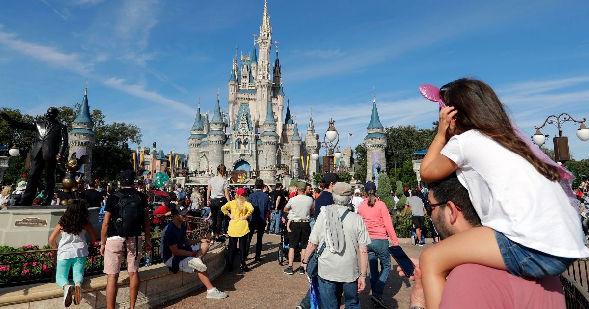 Guests walk near a statue of Walt Disney and Mickey Mouse in front of the Cinderella castle in the Magic Kingdom at Walt Disney World in Lake Buena Vista, Florida, on Jan. 9, 2019.
