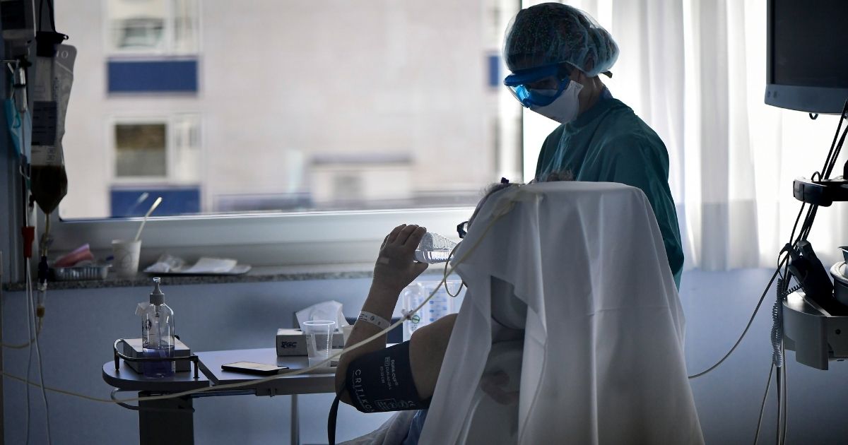 A medical professional helps a patient with COVID-19 in the ICU department of the Clinica Universitaria, in Pamplona, Spain, on Jan. 12.