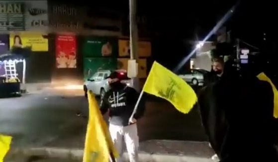 Hezbollah supporters hand out sweets to motorists in Beirut to celebrate a deadly terrorist attack.