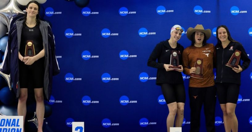 Transgender swimmer Lia Thomas stands on the podium after winning the 500-yard freestyle as the other medalists, from left, Emma Weyant, Erica Sullivan and Brooke Forde, pose for a photo at the NCAA Division I Women's Swimming & Diving Championships in Atlanta on Thursday.