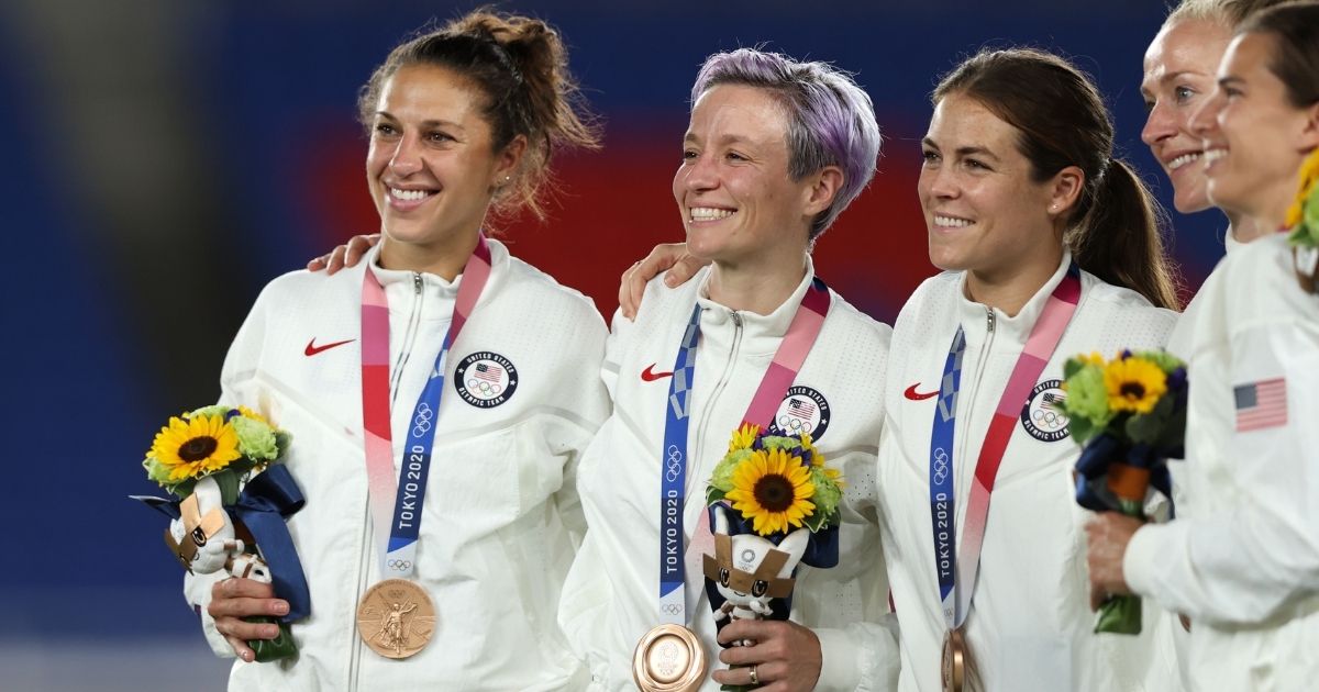 Carli Lloyd, left, stands next to Megan Rapinoe and other teammates after the U.S. women received their bronze medals at International Stadium Yokohama on Aug. 6, 2021, following a disappointing third-place finish in the Tokyo Olympics.