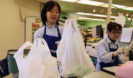 A cashier places groceries in plastic bags at Nijiya Market in San Francisco on June 2, 2010.