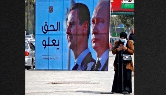 A banner depicting Syrian President Bashar al-Assad and Russian President Vladimir Putin and reading 'Justice Prevails' is displayed along a highway in the Syrian capital Damascus, on March 8. The Russian government claims Syrians are volunteering to come fight as Russia struggles in its invasion of Ukraine.