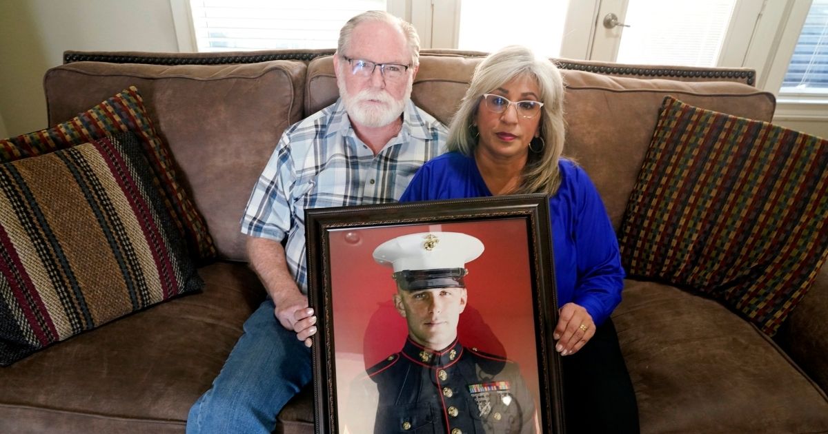 Joey and Paula Reed hold a portrait of their son, Marine Corps veteran and Russian prisoner Trevor Reed, at their home in Fort Worth, Texas, on Feb. 15.