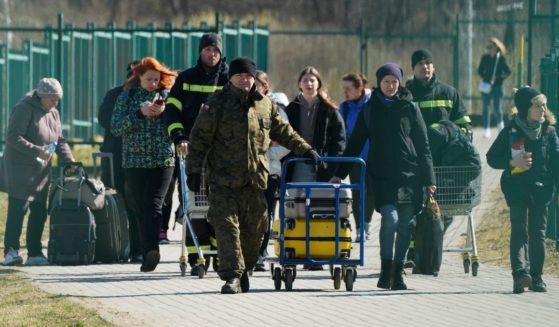 A group of refugees cross the border from Ukraine into Medyka, Poland, on Sunday after being displaced during Russia's invasion of the country.