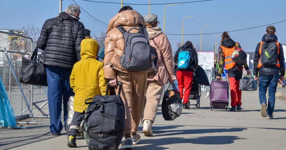 A stock photo shows refugees from Ukraine heading into Slovakia.