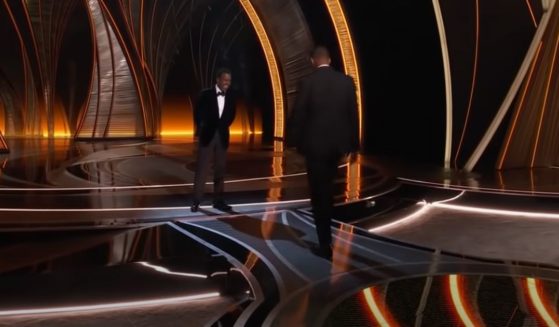 Will Smith, right, approaches Chris Rock at the Oscars on Sunday night.