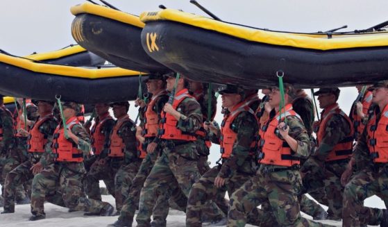 Navy SEAL trainees participate in training exercises, carrying inflatable boats at Naval Amphibious Base Coronado in Coronado, California, on May 14, 2009.