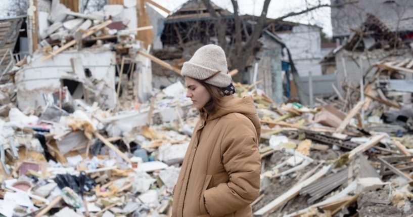 A resident stands in front of rubble on Saturday in Markhalivka, Ukraine.
