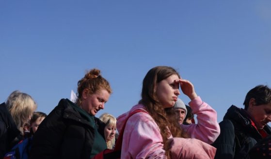 Ukrainian refugees wait to board buses upon their arrival at a border crossing on Tuesday in Medyka, Poland.
