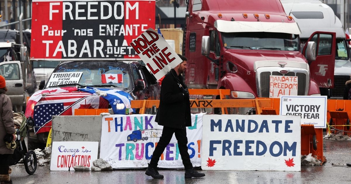 A protester walks in front of parked trucks in a filed photo from Feb. 8 in Ottawa, Canada.