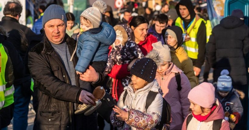 Refugees wait for the bus before continuing the journey after they crossed the Ukrainian-Polish border in Medyka, in southeastern Poland on Saturday.