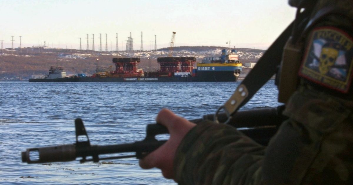 A Russian soldier guards the area as the Russian navy returns the recovered nuclear submarine Kursk to the port of Roslyakovo, near Murmansk, in October 2001.