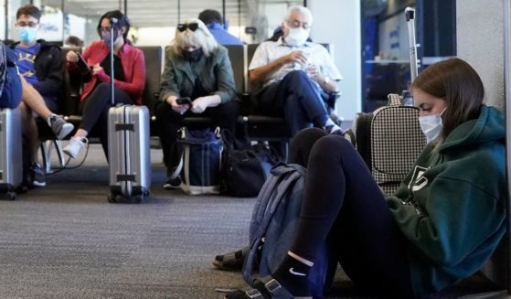Passengers wait to board a United Airlines flight to Hawaii at San Francisco International Airport in San Francisco on Oct. 15, 2020. Per a federal mask mandate all airline passengers are required to wear a mask.