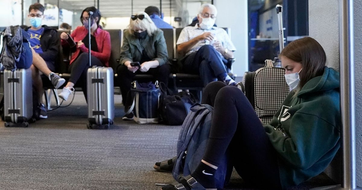 Passengers wait to board a United Airlines flight to Hawaii at San Francisco International Airport in San Francisco on Oct. 15, 2020. Per a federal mask mandate all airline passengers are required to wear a mask.