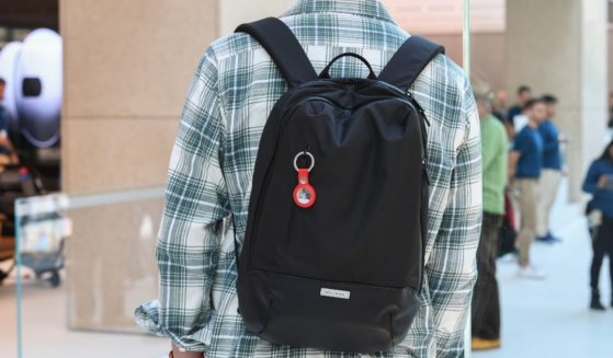 A man wears a backpack with a keyring containing an Apple AirTag on April 30, 2021, in Sydney, Australia.
