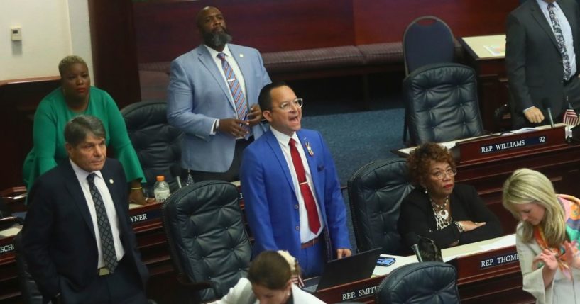 Democratic state Rep. Carlos Guillermo Smith of Orlando (in blue suit) yells his objection as Republicans in the Florida House of Representatives applaud after the Disney bill was passed Thursday at the Capitol in Tallahassee.