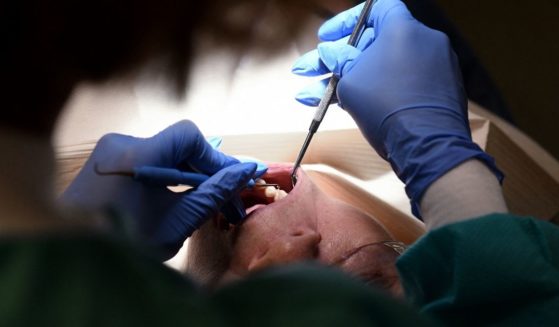 A dental hygienist works on a patient at a dental clinic in Washington, D.C, on Oct. 28, 2021.