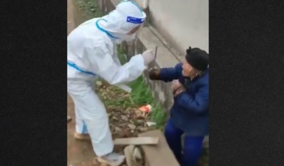 In a video that has gone viral worldwide, an elderly Chinese woman uses a stick to fend off a hazmat-suited individual trying to administer a COVID swab test.