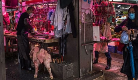 A butcher prepares meat at a fresh food market in Hong Kong on March 24.