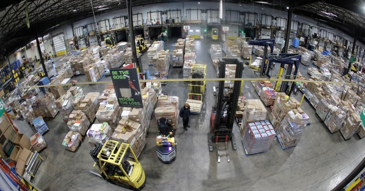Employees work at the Associated Foods Stores distribution warehouse in Farr West, Utah, on March 20, 2020.