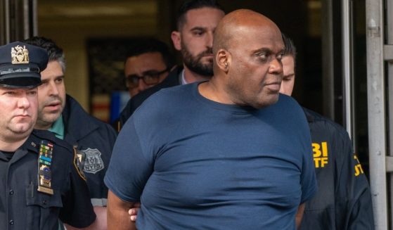 Frank James is escorted by police after being arrested in connection to a mass shooting on Wednesday in New York City.