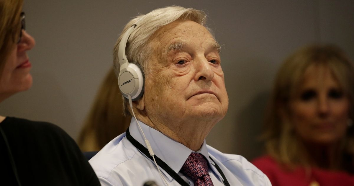 George Soros wears headphones at a U.N. summit on refugees