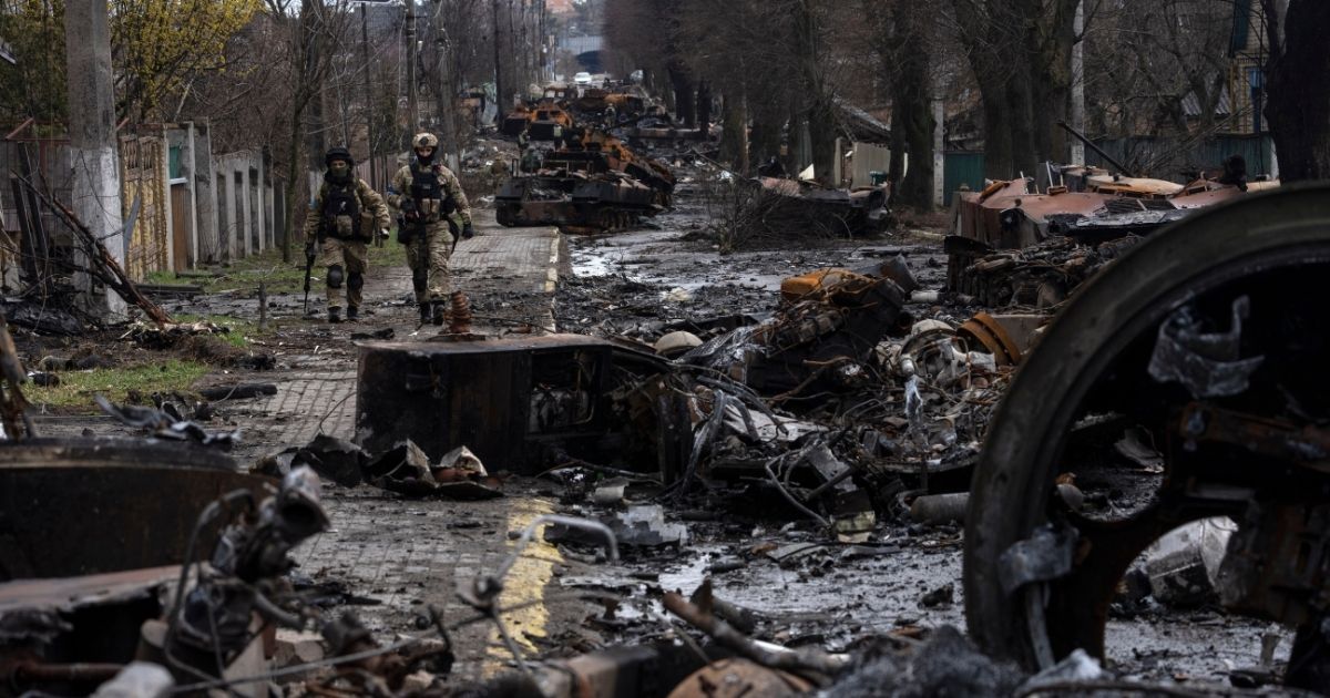 Ukrainian soldiers walk by destroyed Russian tanks in Kyiv, Ukraine, showing just some of the destruction in the streets of the city on Sunday.