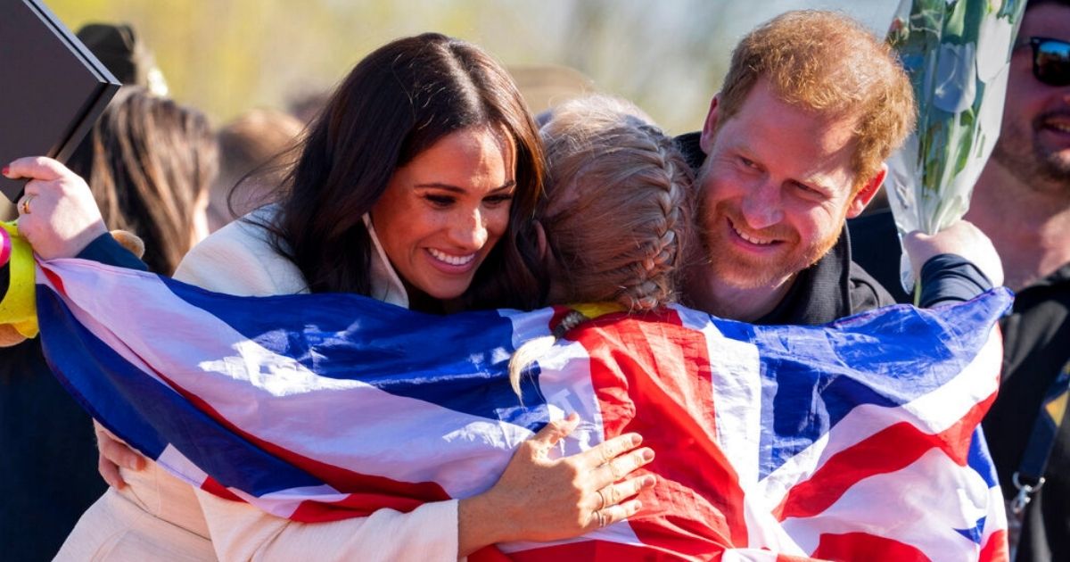 Prince Harry and Meghan Markle, Duke and Duchess of Sussex, hug Lisa Johnston, a former army medic and amputee, who celebrated with her medal at the Invictus Games in The Hague, Netherlands, Sunday. Harry told child journalists at the event that his goal is to work to create 'a more equal world.'