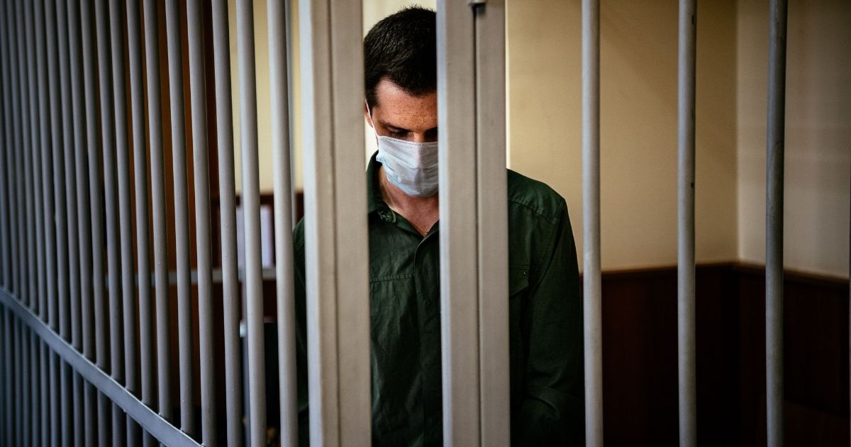 Former U.S. Marine Trevor Reed stands inside a defendant's cage at Moscow's Golovinsky district court in Russia to hear his verdict on July, 30, 2020.