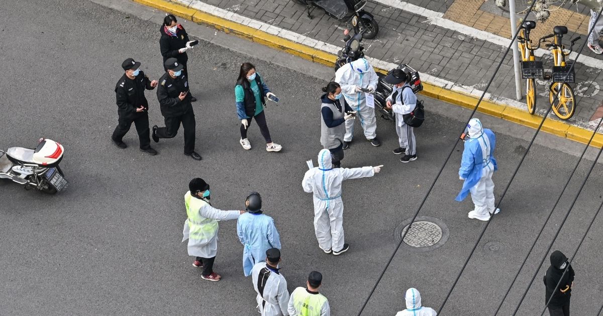 A health worker wearing personal protective gear gestures to residents on a street during the second stage of a Covid-19 lockdown in Shanghai on Friday.