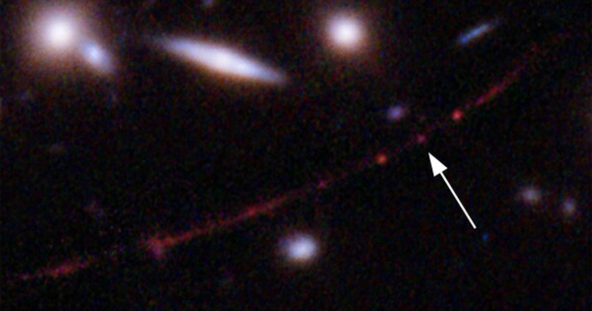 This image made available by NASA on March 30, 2022, shows the star Earendel, indicated by arrow, and an arc galaxy, stretching from lower left to upper right, optically bent due to a massive galaxy cluster between it and the Hubble Space Telescope, which captured the light. The mass of the galaxy cluster serves as a magnifying glass, allowing Earendel to be seen.