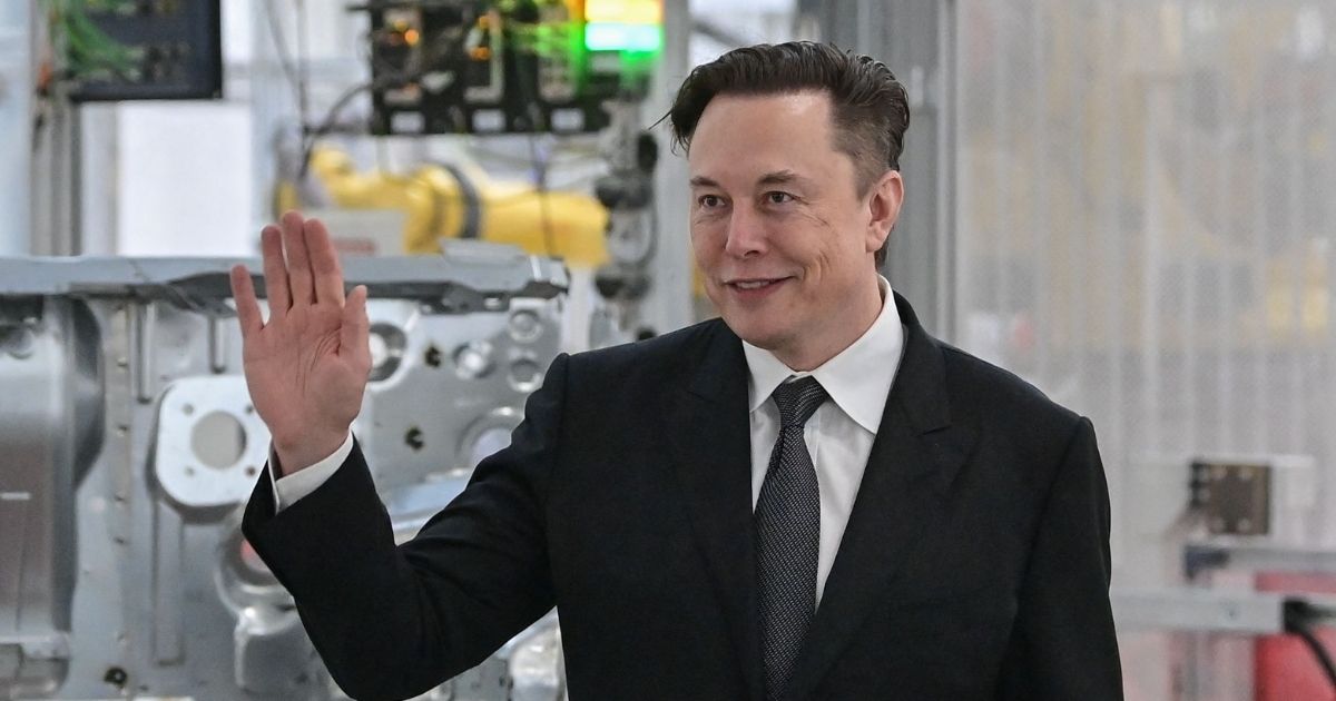 Mega-billionaire and Tesla CEO Elon Musk waves in a file photo from a visit to an electic car plant in Gruenheide, Germany, in March.