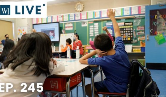 Students raise their hands at Yung Wing School P.S. 124 in New York City on Sept. 27, 2021.