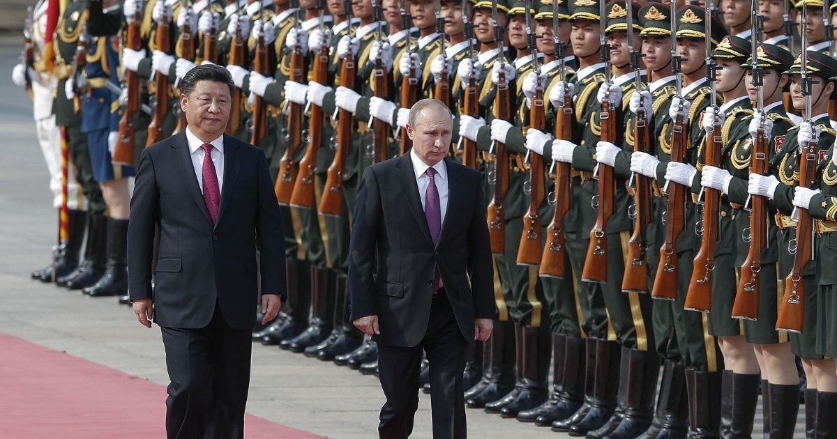 Chinese President Xi Jinping accompanies Russian President Vladimir Putin to view an honor guard outside the Great Hall of the People in Beijing, on June 25, 2016.
