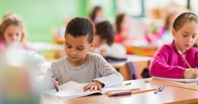 Children draw in a classroom in the above stock image.