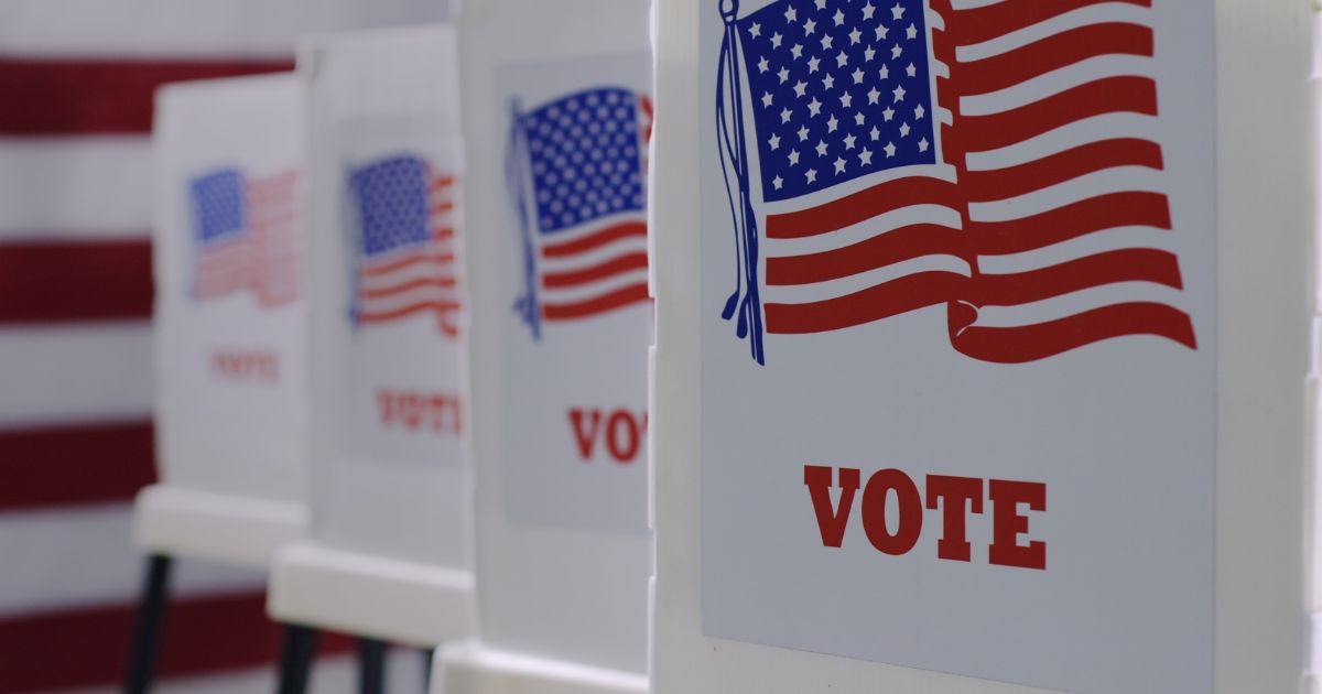 A stock photo shows voting booths in a row.