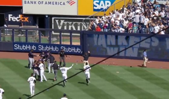 New York Yankees fans throw trash on the field after the team's win on Saturday.
